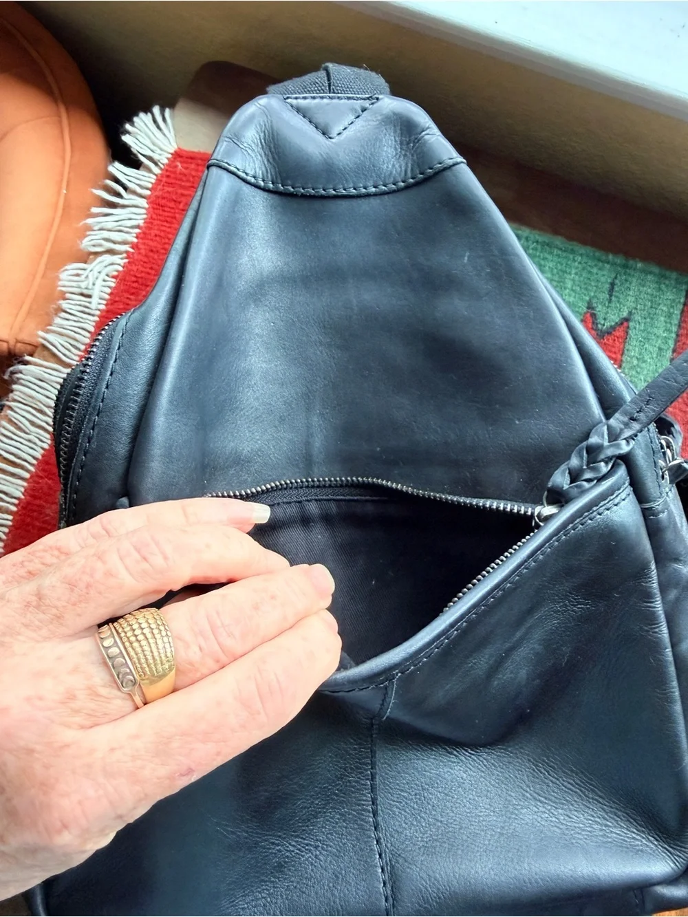 Black trianglular leather backpack with multiple pockets